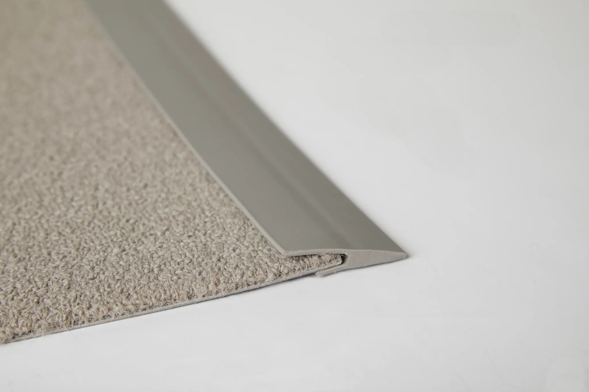 Close-up of beige commercial carpet tile with edge trim