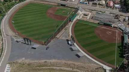 Scenic aerial shot of baseball fields with lush grass Aerial view of two baseball fields with green grass and brown infields
