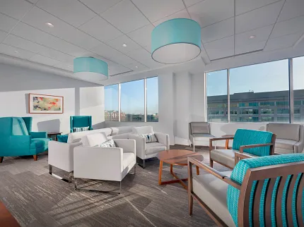 Healthcare Facility Waiting Area with Commercial Carpet Tile Flooring Modern healthcare facility waiting area with teal and white seating, featuring commercial carpet tile flooring in a neutral gray pattern