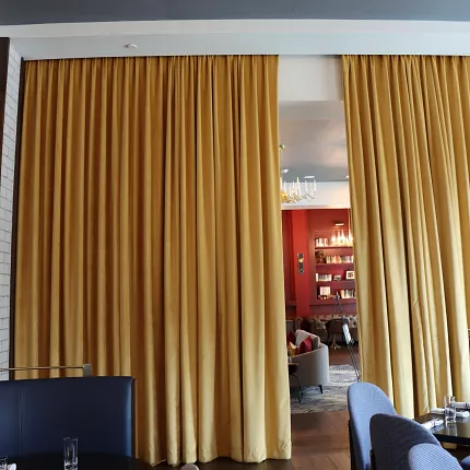 Sophisticated dining area with stylish wood flooring Elegant restaurant interior with wooden flooring and gold curtains
