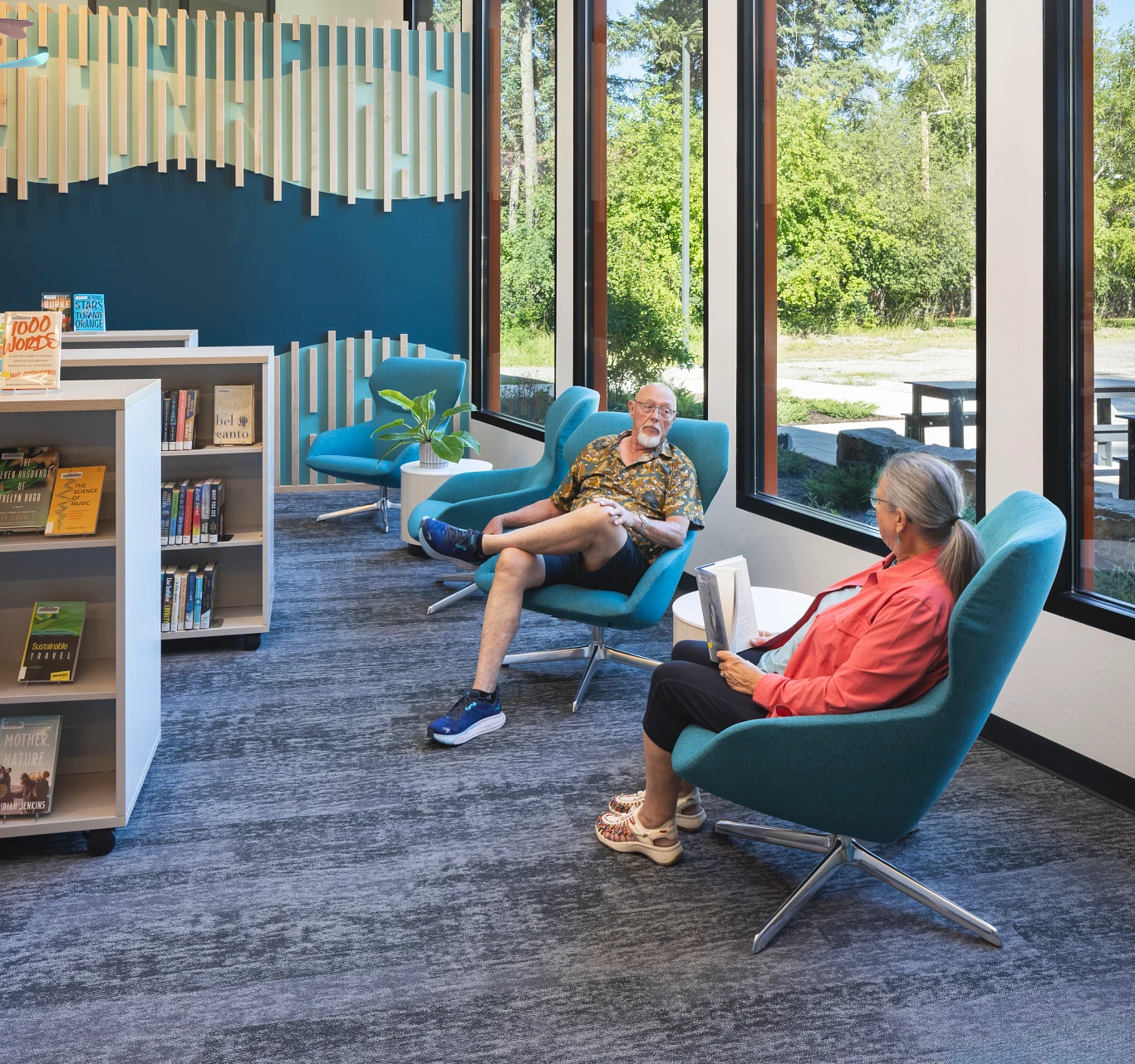 A couple sitting in chairs enjoying the library