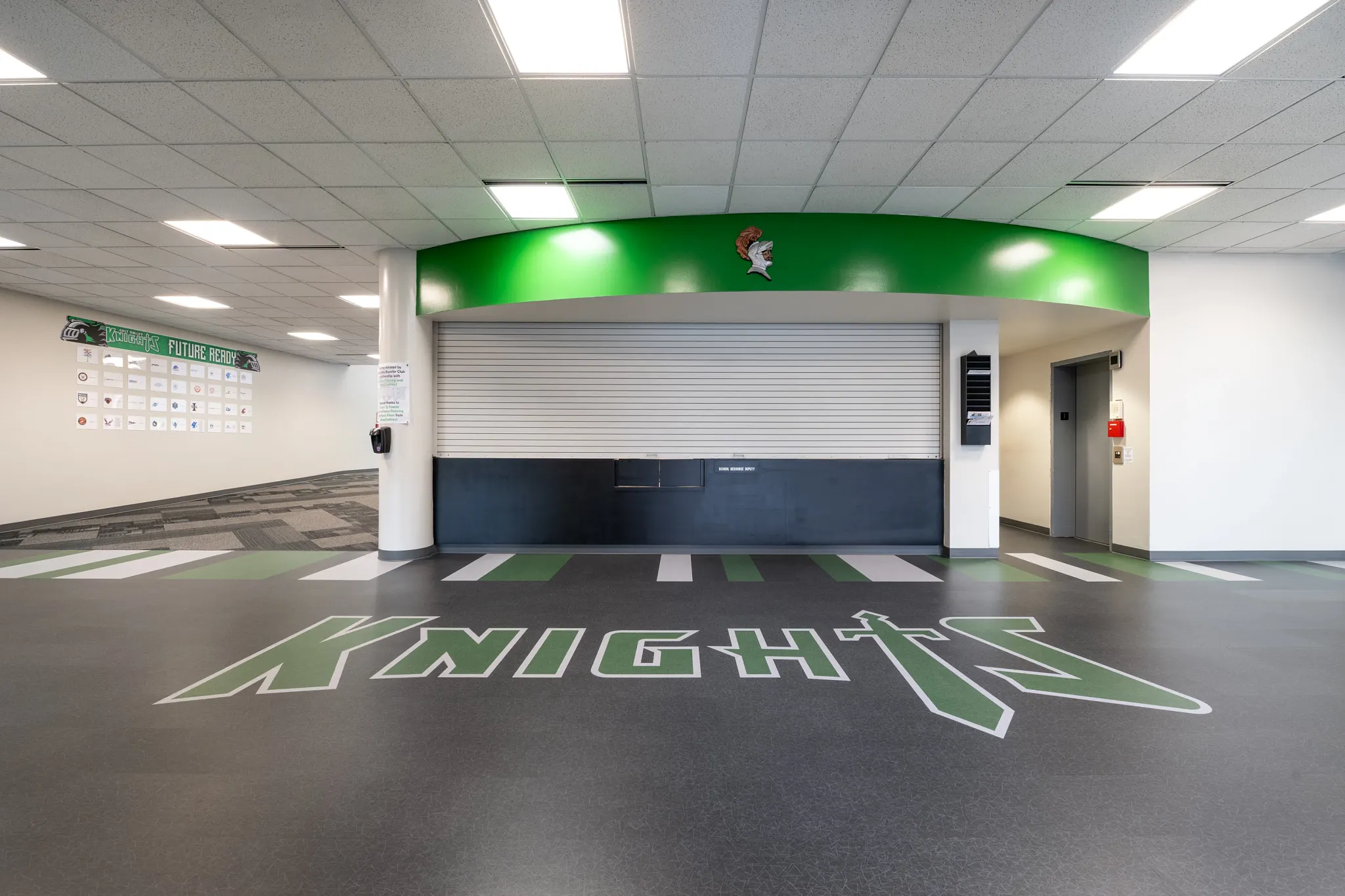 Education facility with heavy commercial luxury vinyl tile flooring featuring "Knights" logo