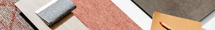 Commercial Carpet Tile and Wood Plank Flooring Swatches Display Assorted flooring swatches including red, gray, and beige commercial carpet tiles and a light wood plank