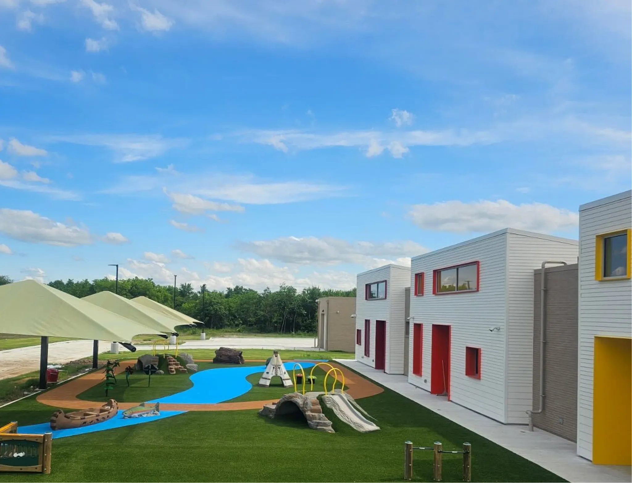 Modern outdoor playground with colorful structures and artificial grass