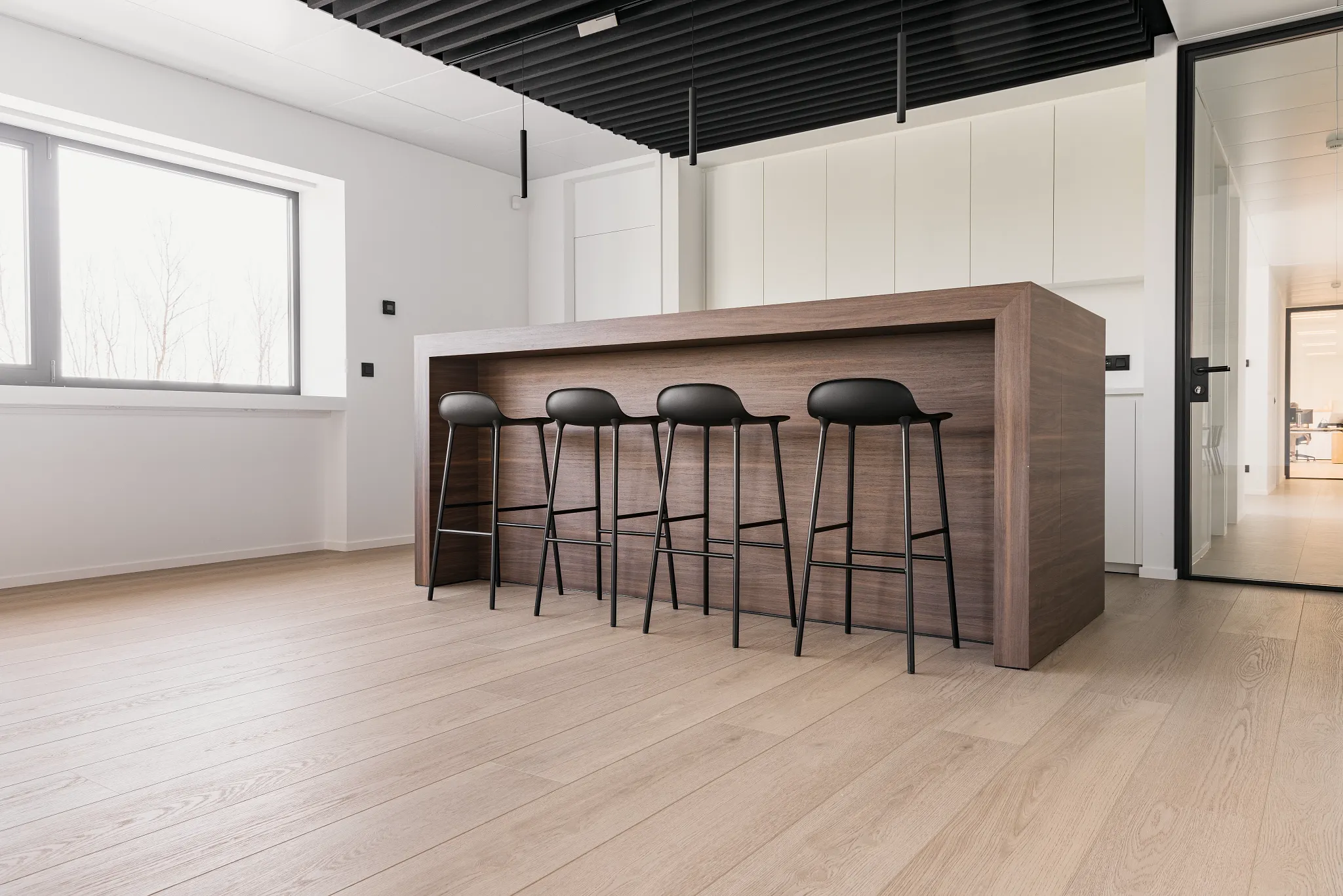 Modern kitchen with wood look vinyl flooring and sleek bar stools