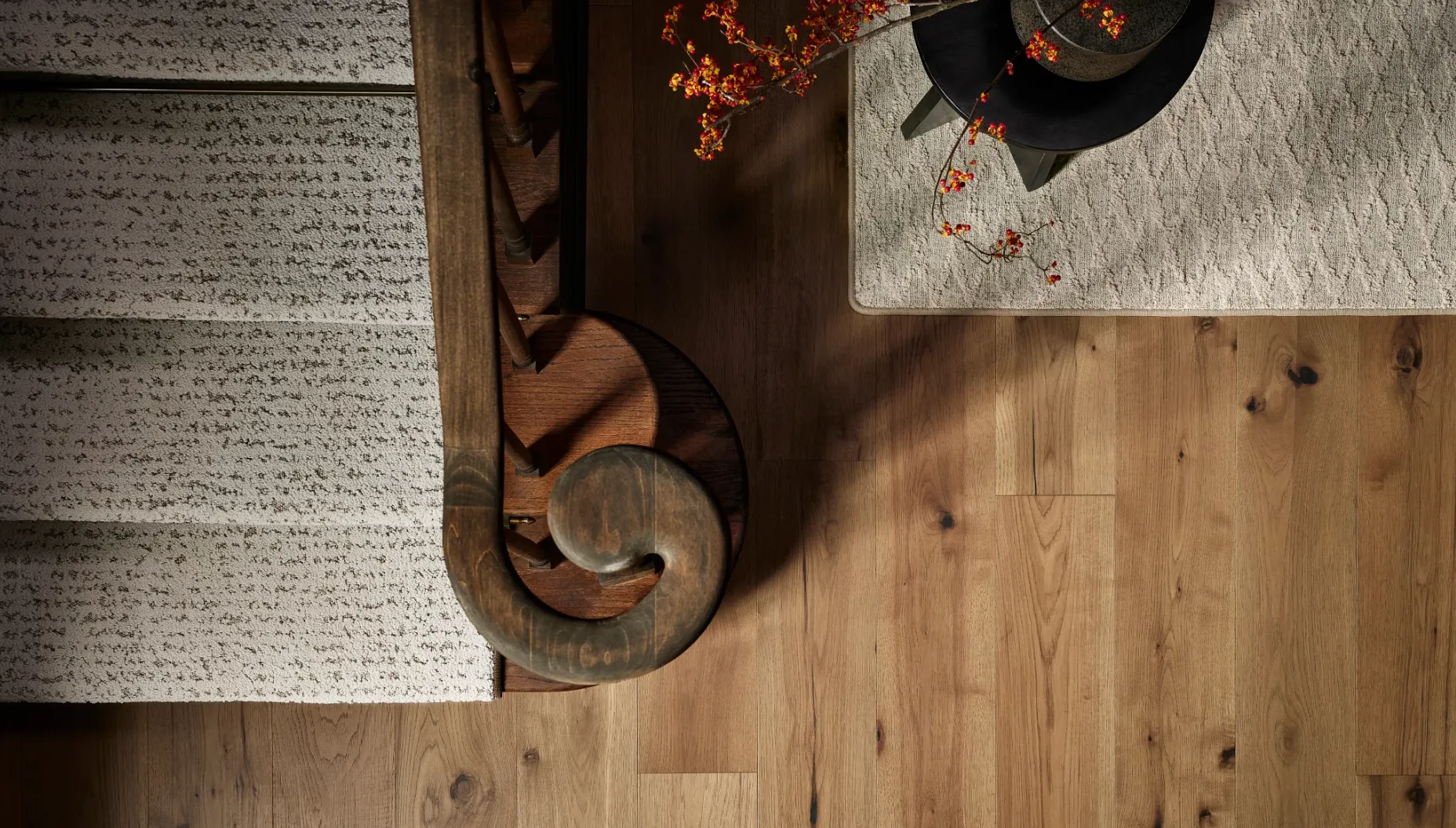 Hardwood flooring with staircase and rug in a cozy interior
