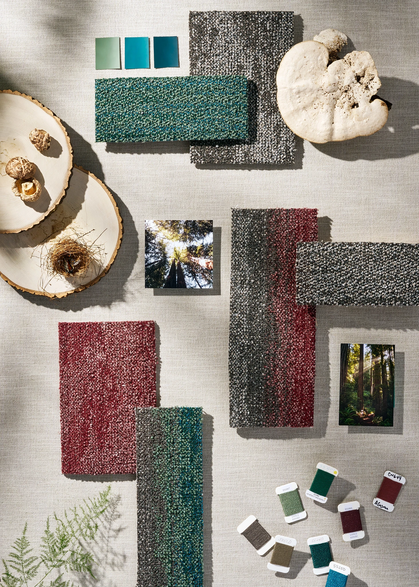 Swatch of commercial carpet tiles in shades of green, blue, red, and gray with natural elements and color samples
