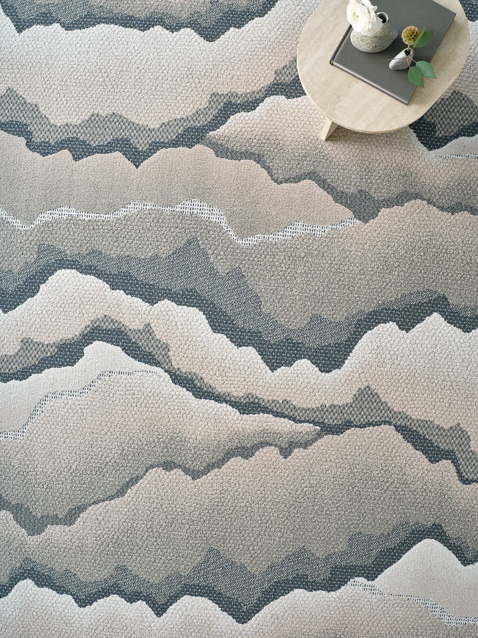 Abstract patterned carpet in shades of beige and gray with a round table