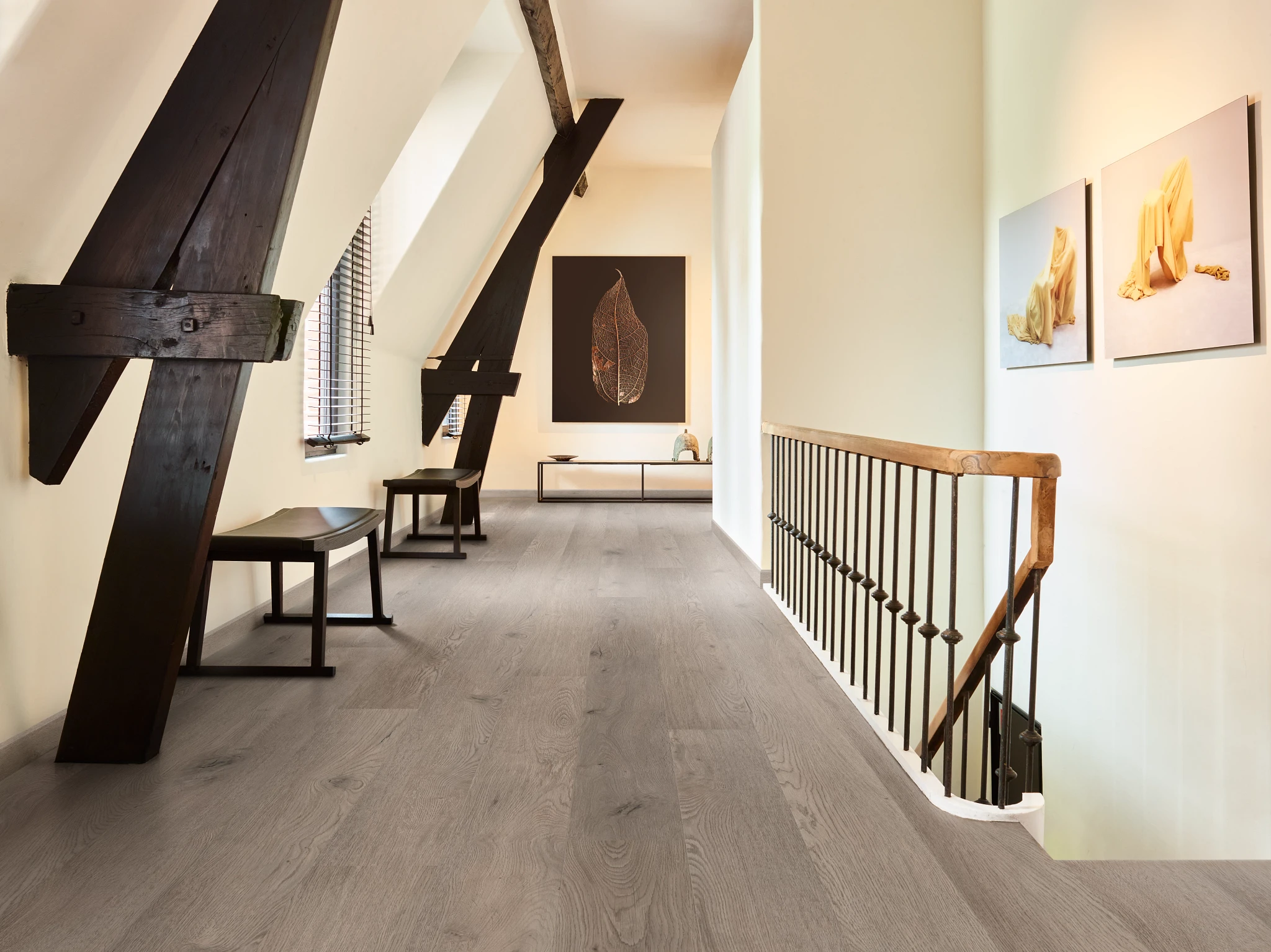 Modern hallway with wood look luxury vinyl plank flooring featuring light gray tones and rustic beams