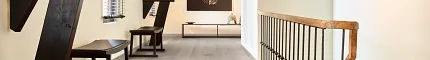 Light Gray Wood Look Luxury Vinyl Plank Flooring in Modern Hallway Modern hallway with wood look luxury vinyl plank flooring featuring light gray tones and rustic beams