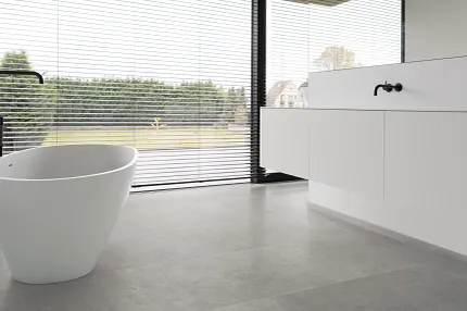 Light Gray Stone Look Luxury Vinyl Tile Flooring in Modern Bathroom Modern bathroom with large windows featuring stone look luxury vinyl tile flooring in a light gray color