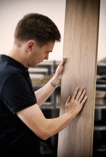 Wood Look Luxury Vinyl Plank Flooring Inspection in Workshop Man examining wood look luxury vinyl plank flooring in a workshop setting