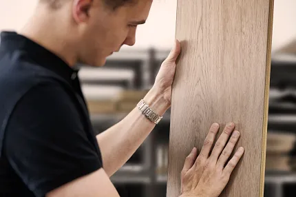 Wood Look Luxury Vinyl Plank Flooring Inspection in Workshop Man examining wood look luxury vinyl plank flooring in a workshop setting