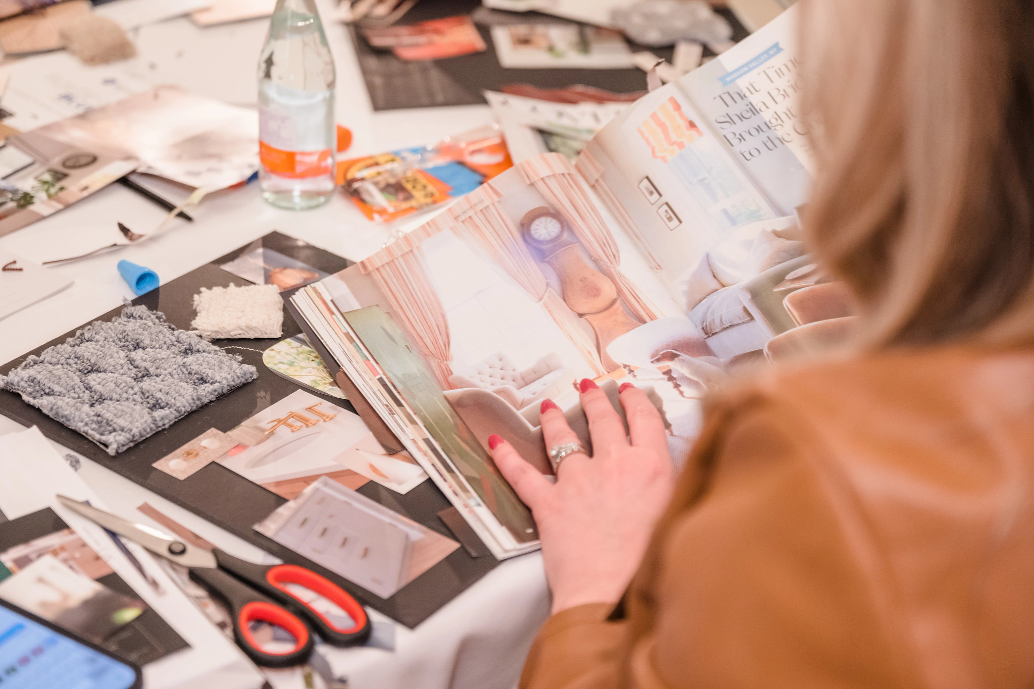 Designer Studying Magazine, with carpet swatch and cut out graphics