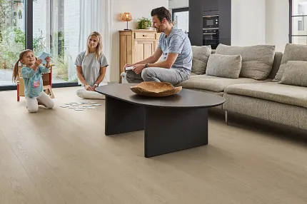 Light Wood Look Luxury Vinyl Plank Flooring in Modern Living Room Scene Modern living room with light wood look luxury vinyl plank flooring, featuring a family enjoying quality time together