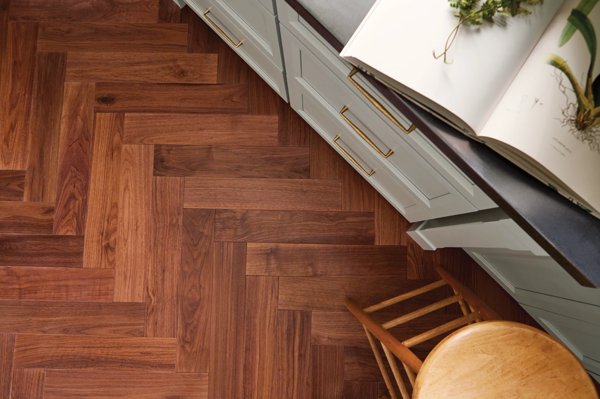 Top down view of a herringbone hardwood floor in a kitchen