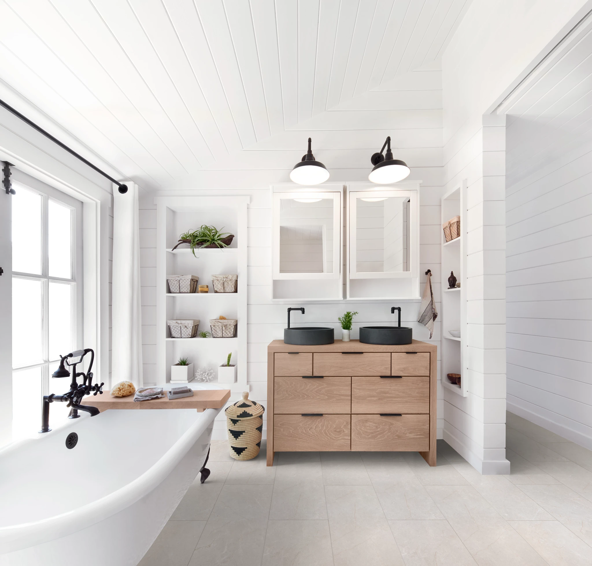 bathroom with luxury vinyl tile floor in a light stone look with a freestanding bathtub and wooden vanity