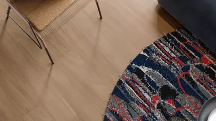 Light Wood Flooring in Modern Living Room with Colorful Rug Modern living room with light wood flooring, a brown chair, and a colorful round rug