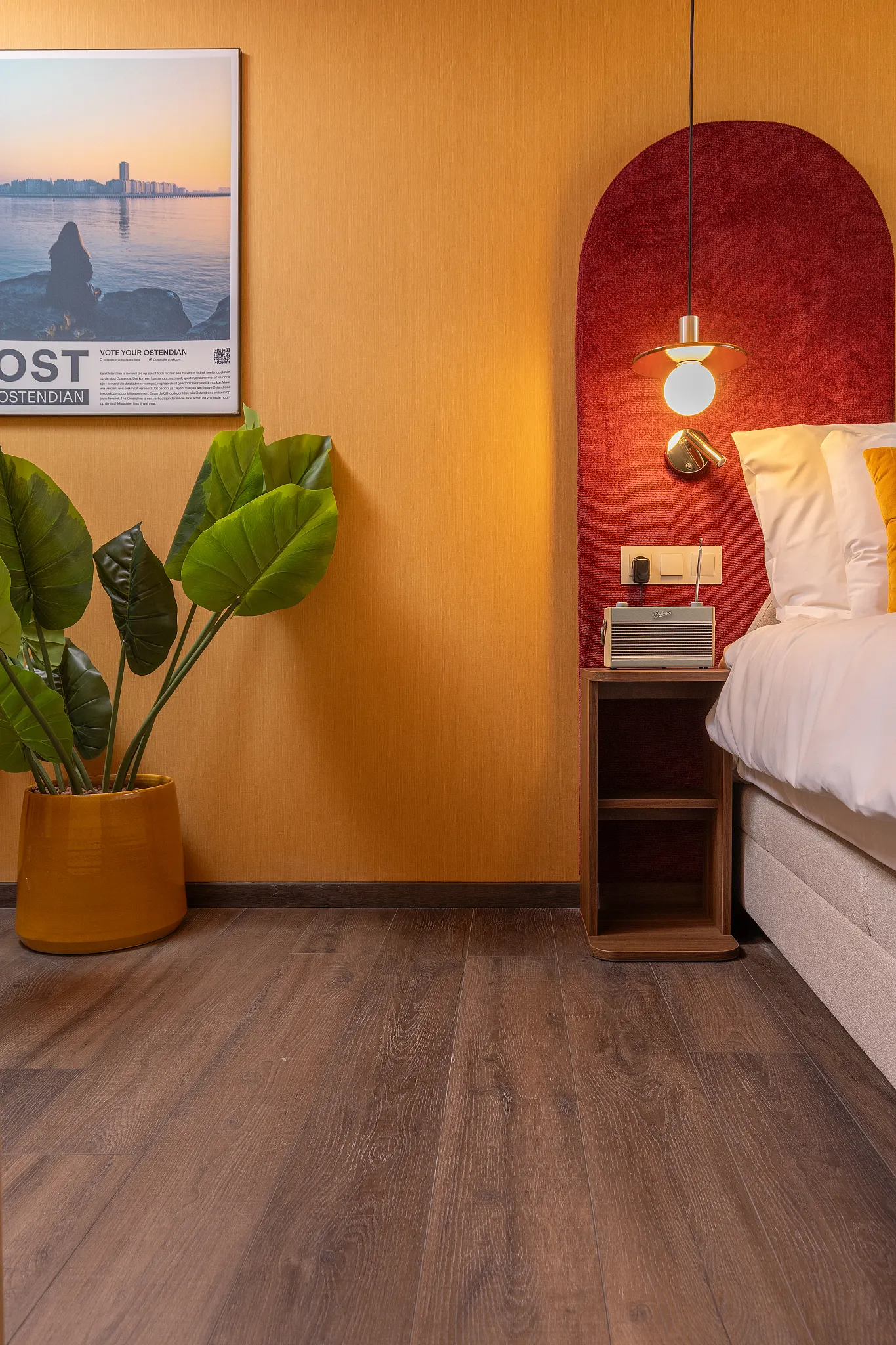 Colourful bedroom with warm orange and red wall and warm wooden Coretec floor