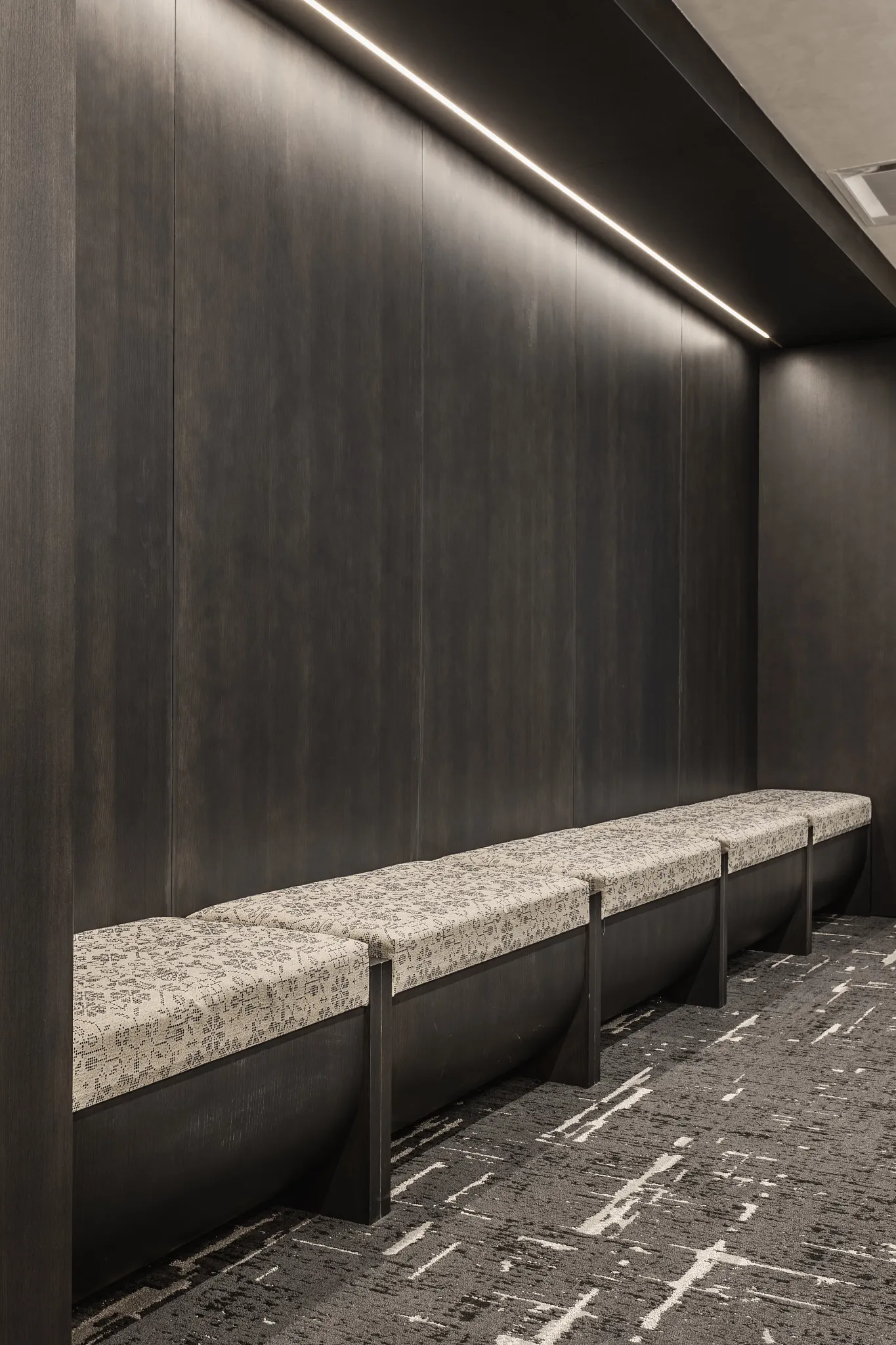 Dark carpet tile flooring in a modern interior with patterned bench seating