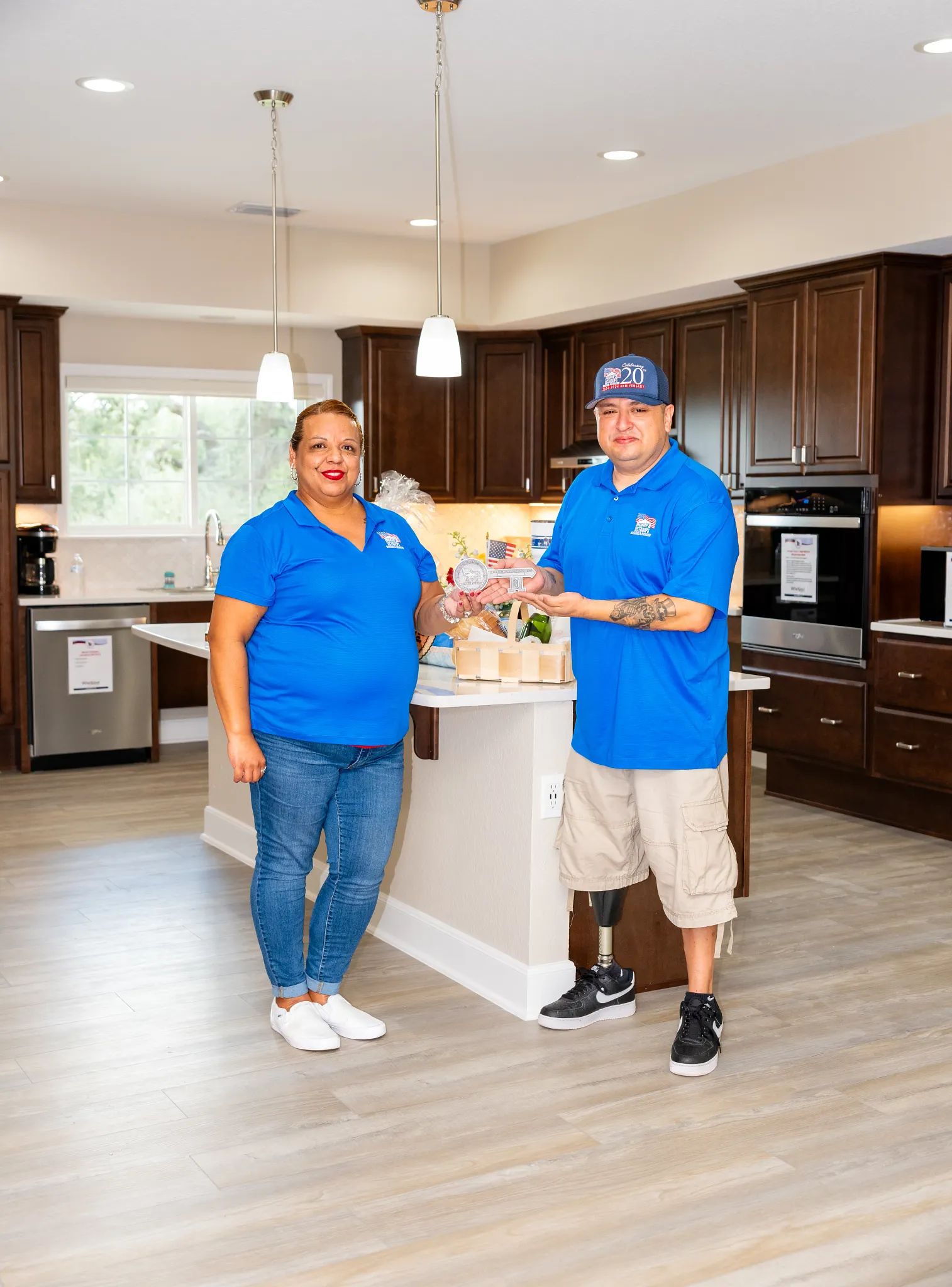 Modern kitchen with wood look luxury vinyl plank flooring and two people in blue shirts