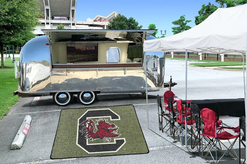Custom artificial turf mat featuring a large Gamecocks “C” logo displayed outside a mobile trailer at a tailgating event.
