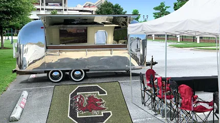 Custom Logo Turf Mat for Tailgating and Events | Shaw Grass Custom artificial turf mat featuring a large Gamecocks “C” logo displayed outside a mobile trailer at a tailgating event.