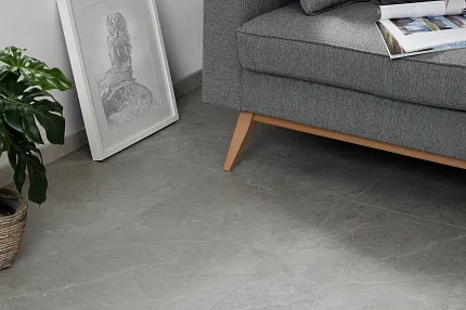 Gray Luxury Vinyl Tile Flooring in Modern Living Room Scene Modern living room with gray luxury vinyl tile flooring, gray sofa, and indoor plant