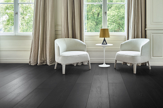 A room with black COREtec vinyl flooring and white chairs..