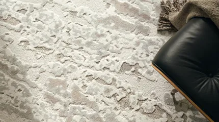Stylish neutral carpet for modern living spaces Textured carpet in neutral tones with a black leather chair