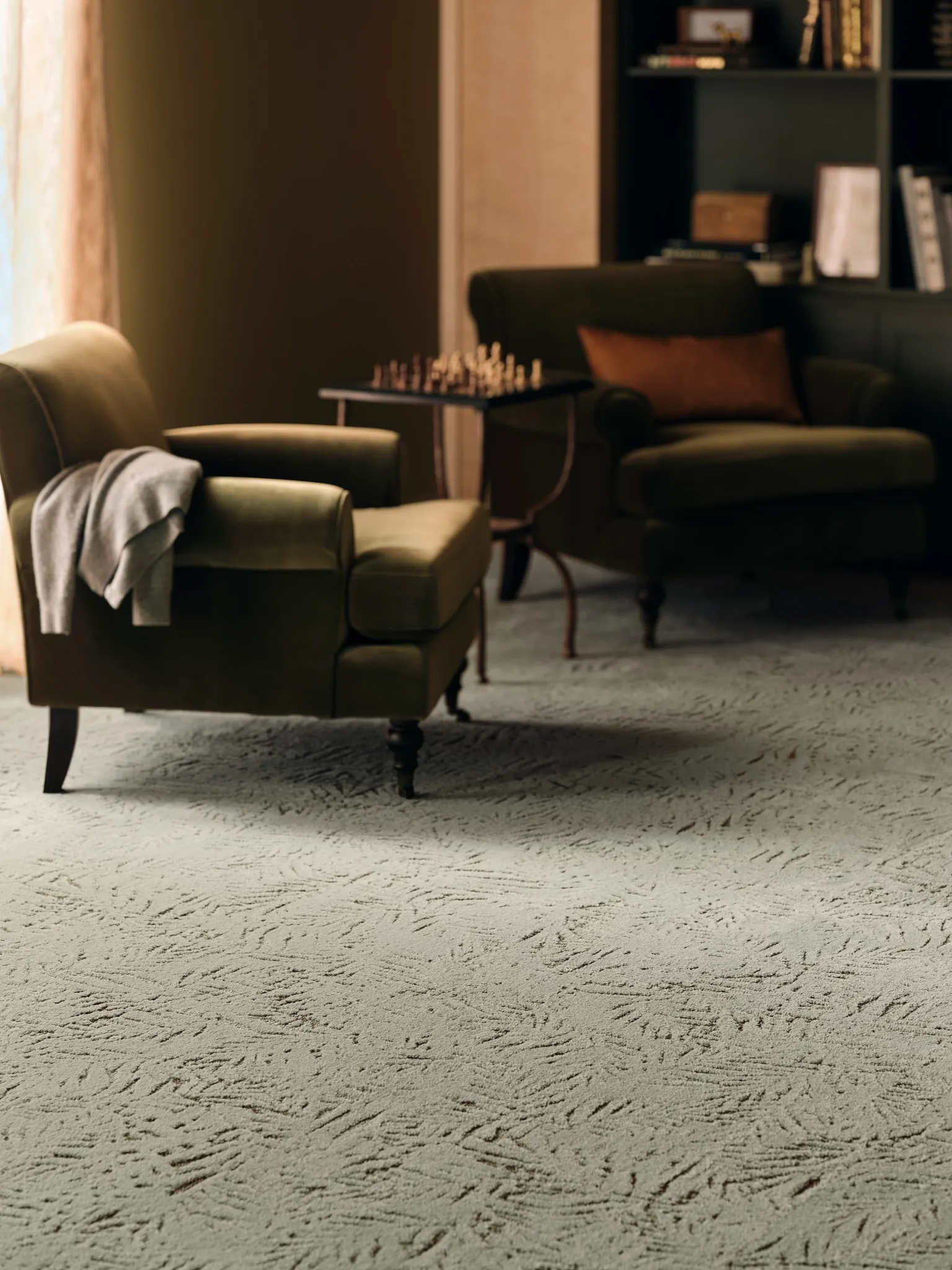 Cozy living room with plush carpet flooring featuring a subtle textured pattern, two olive green armchairs, and a chess table