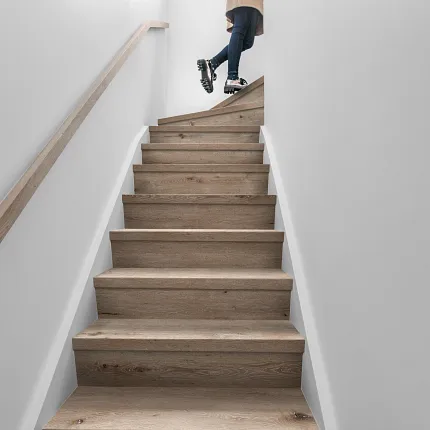 Wood Look Luxury Vinyl Plank Flooring on Staircase - Durable and Stylish Modern staircase with wood look luxury vinyl plank flooring and a person walking up