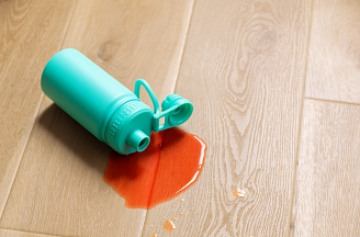 A bottle spill kept on the surface of vinyl flooring thanks to COREtec’s waterproof technology.