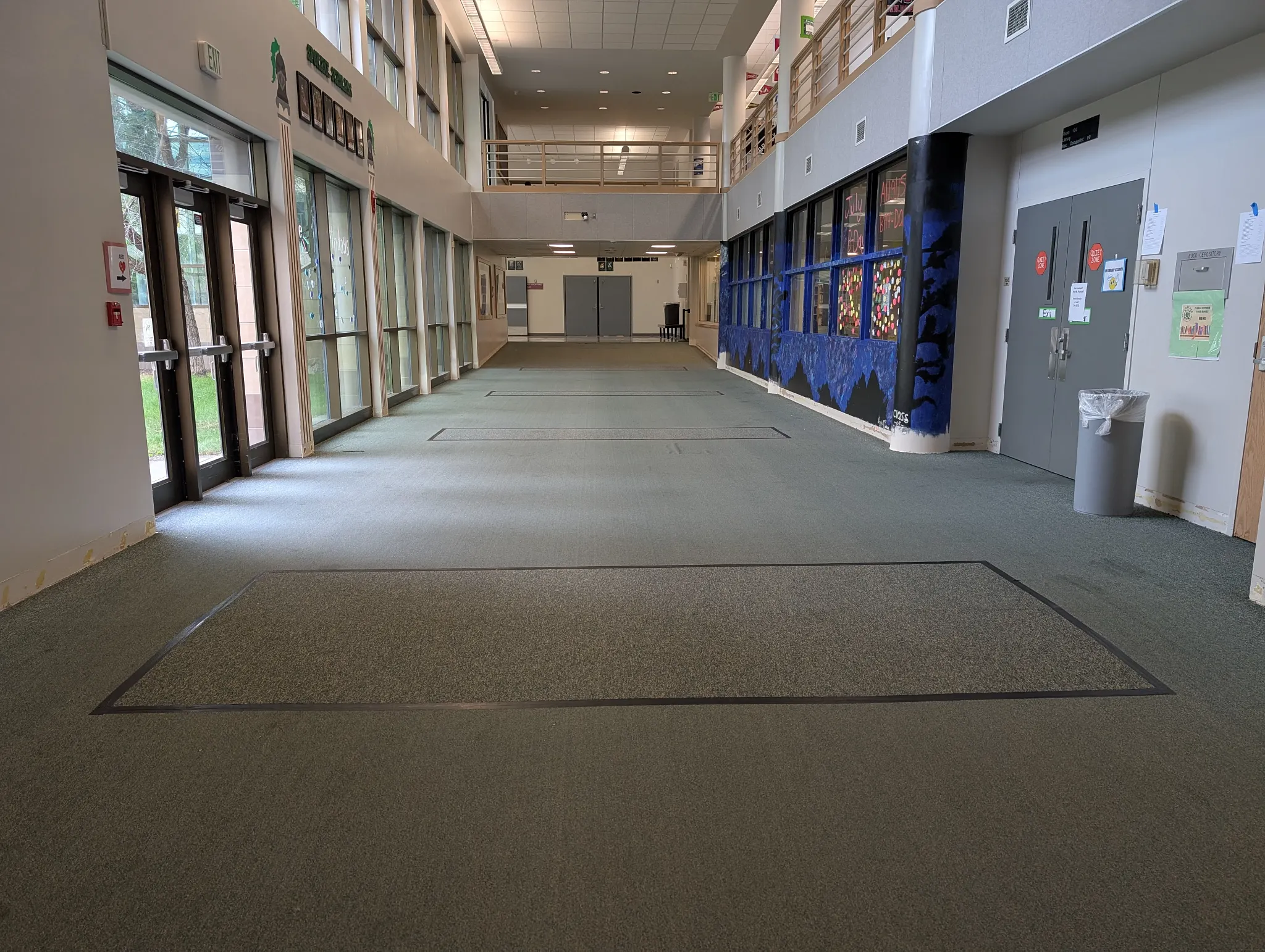 Green carpet flooring in a spacious hallway