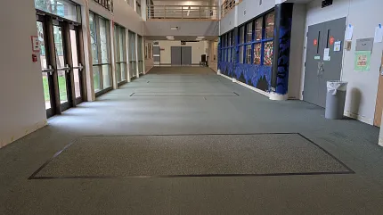 Durable green carpet for high-traffic areas Green carpet flooring in a spacious hallway