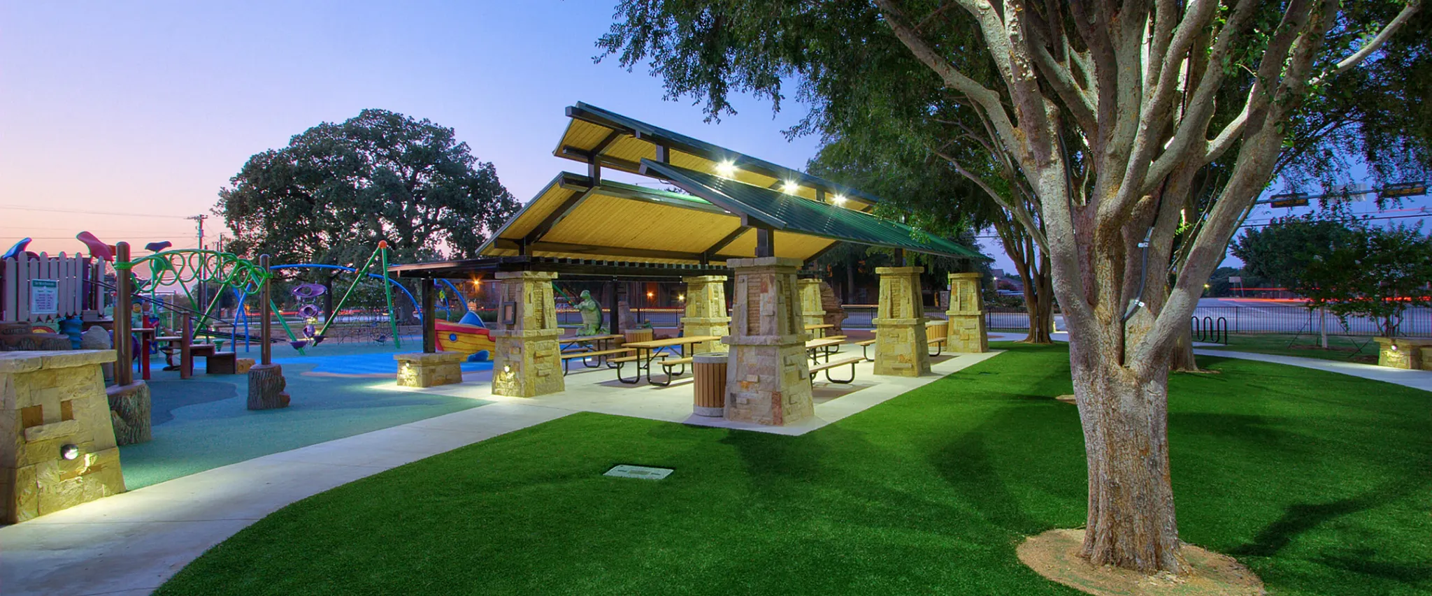 Scenic view of a park with playground and picnic area at dusk