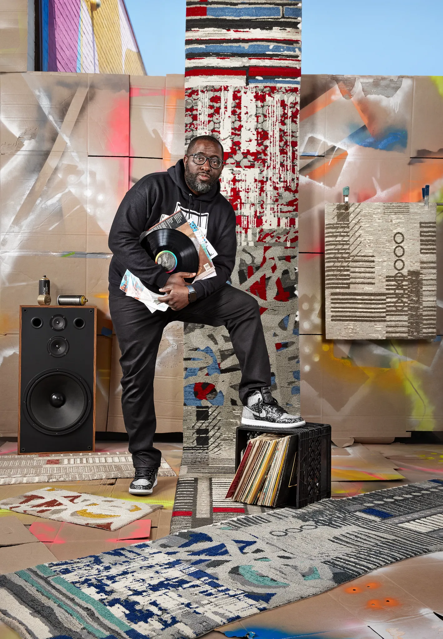 "Colorful abstract commercial carpet tiles with geometric patterns in a creative studio setting featuring a speaker and vinyl records, suitable for retail or workplace environments"