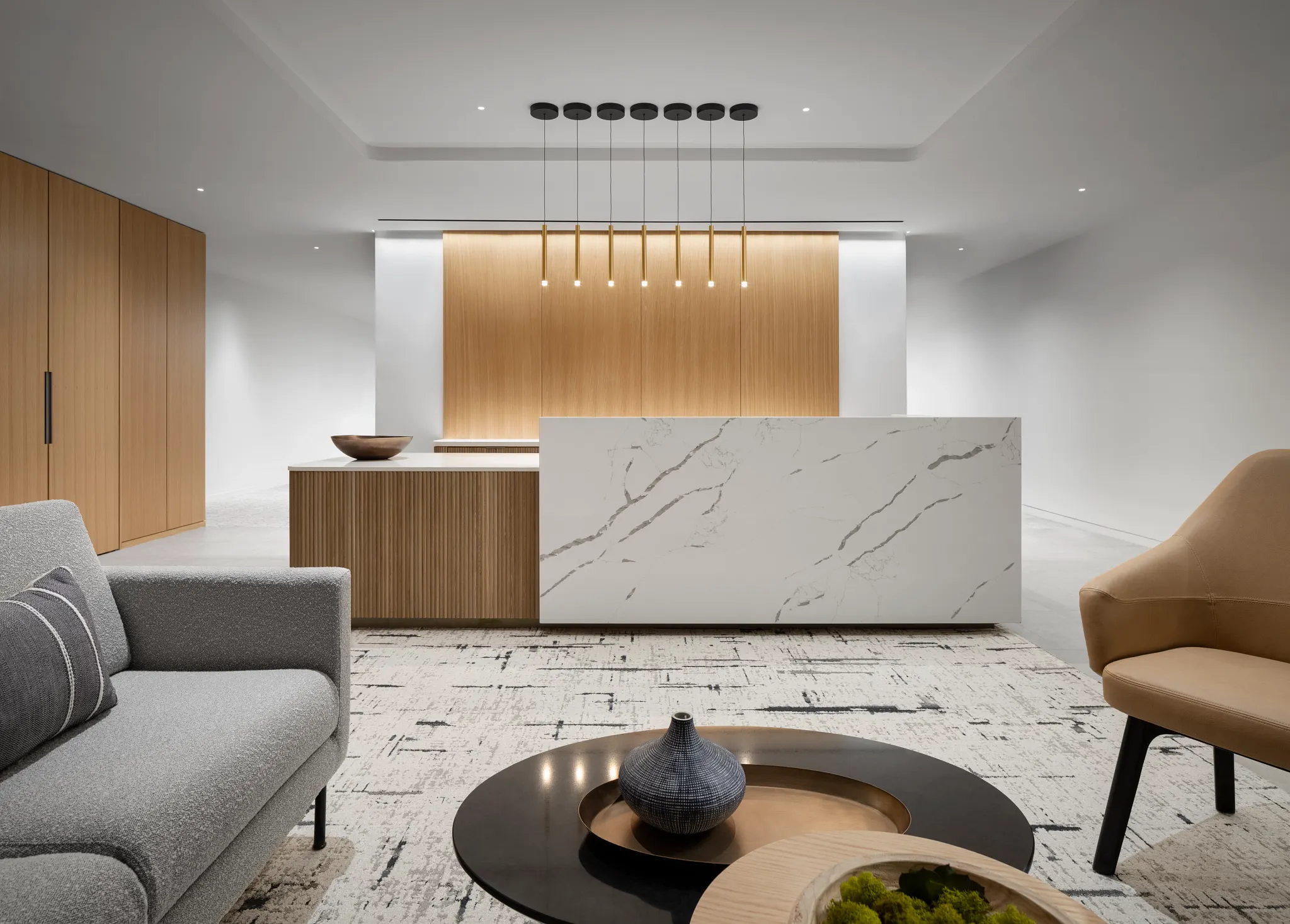 Modern workplace interior with commercial carpet tile flooring in 18x36 inch dimensions, featuring a sleek reception area with a marble counter and contemporary furniture.