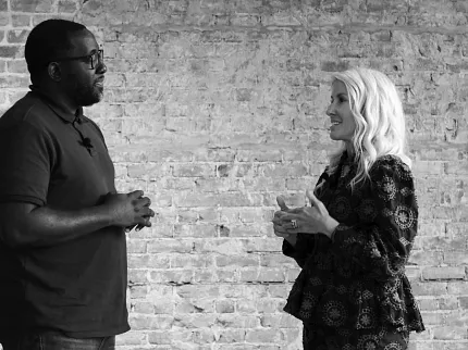 Conversation scene with textured brick wall background Two people conversing in front of a textured brick wall