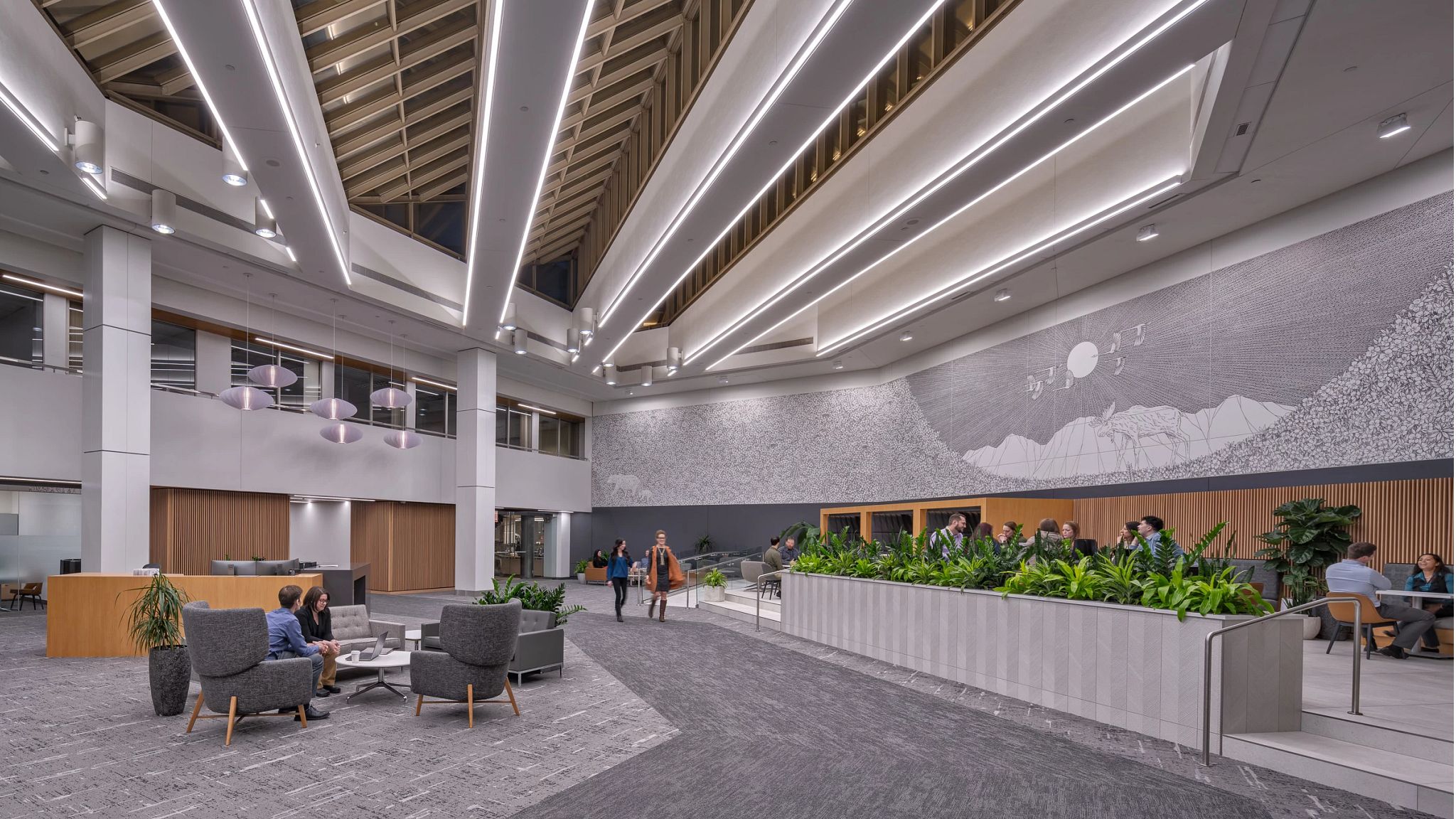 Interior lobby of atrium with people walking around and sitting in a cafe featuring commercial carpet tile