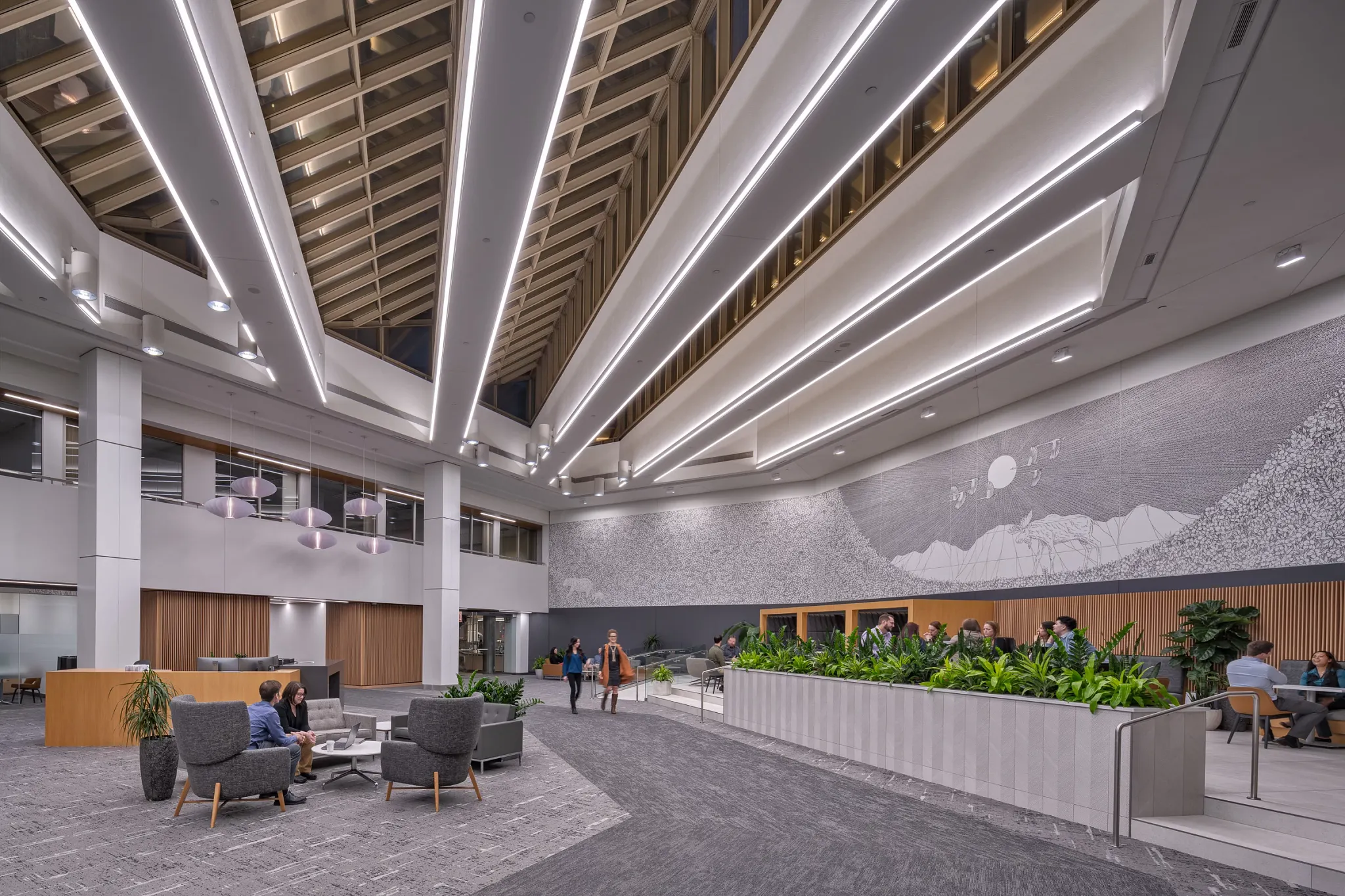 Modern workplace lobby with high ceilings, contemporary lighting, and grey commercial carpet flooring