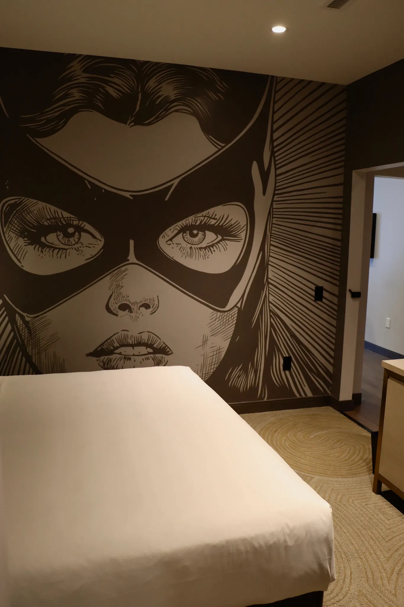 Modern hotel room with beige carpet flooring and artistic wall design