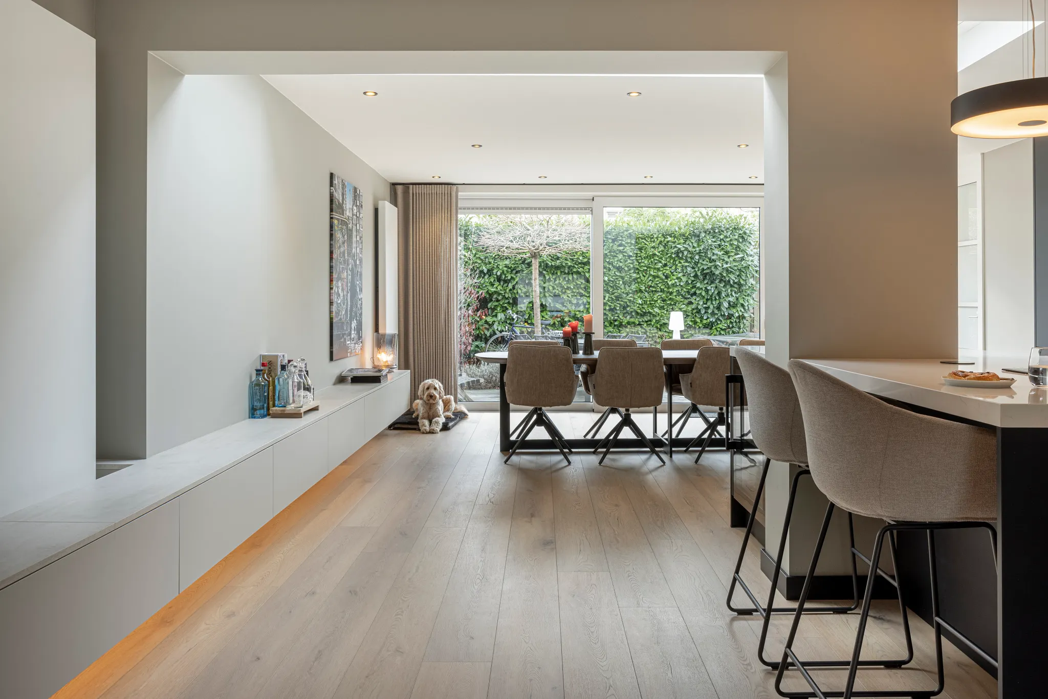 Modern living room with light wood flooring and dining area