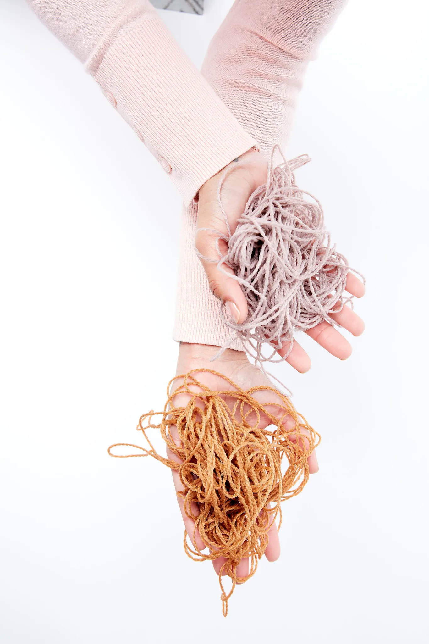 Spools of colorful yarn in various shades including red, blue, green, yellow, orange, and black arranged on a white background