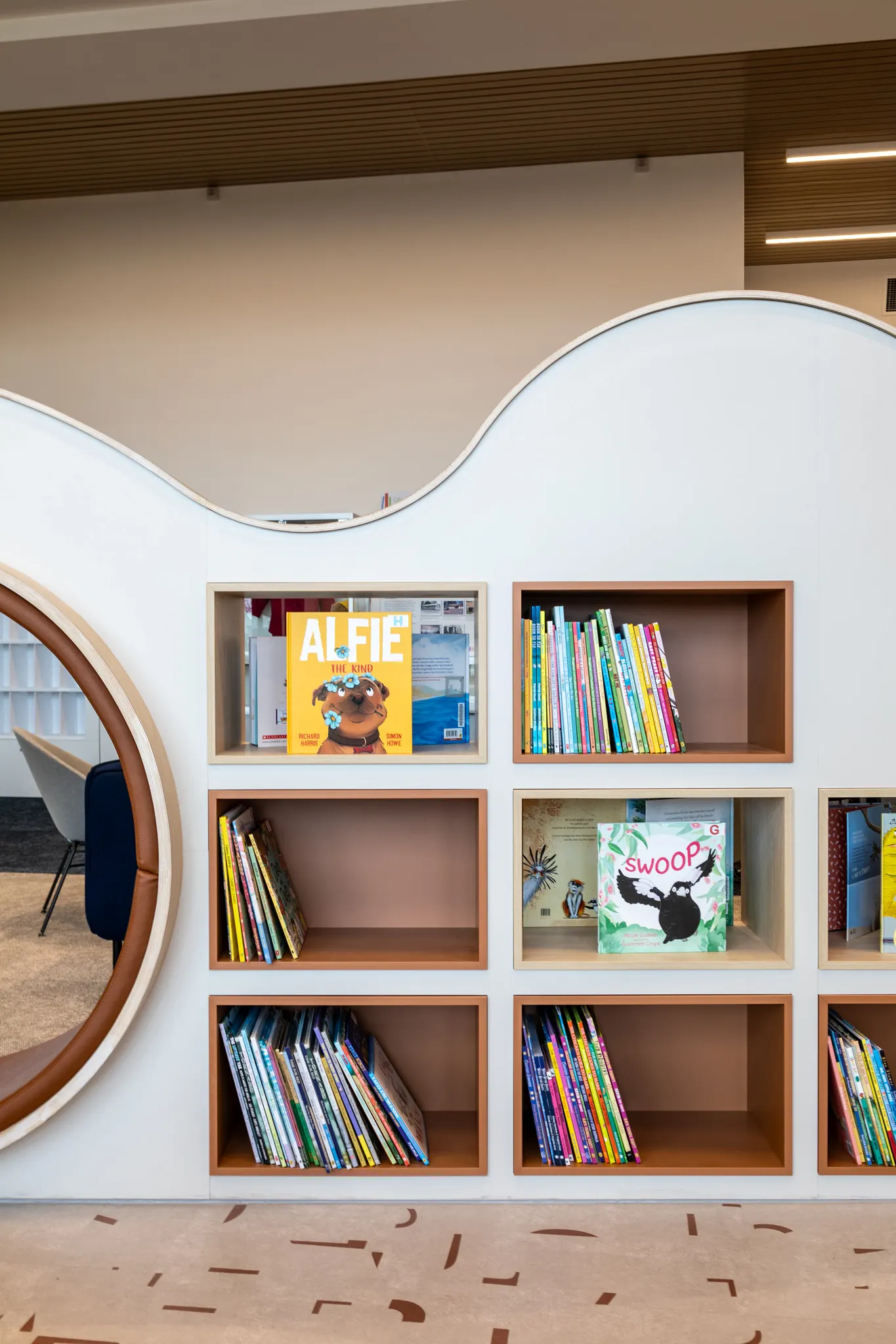 Modern library interior with unique shelving and patterned flooring