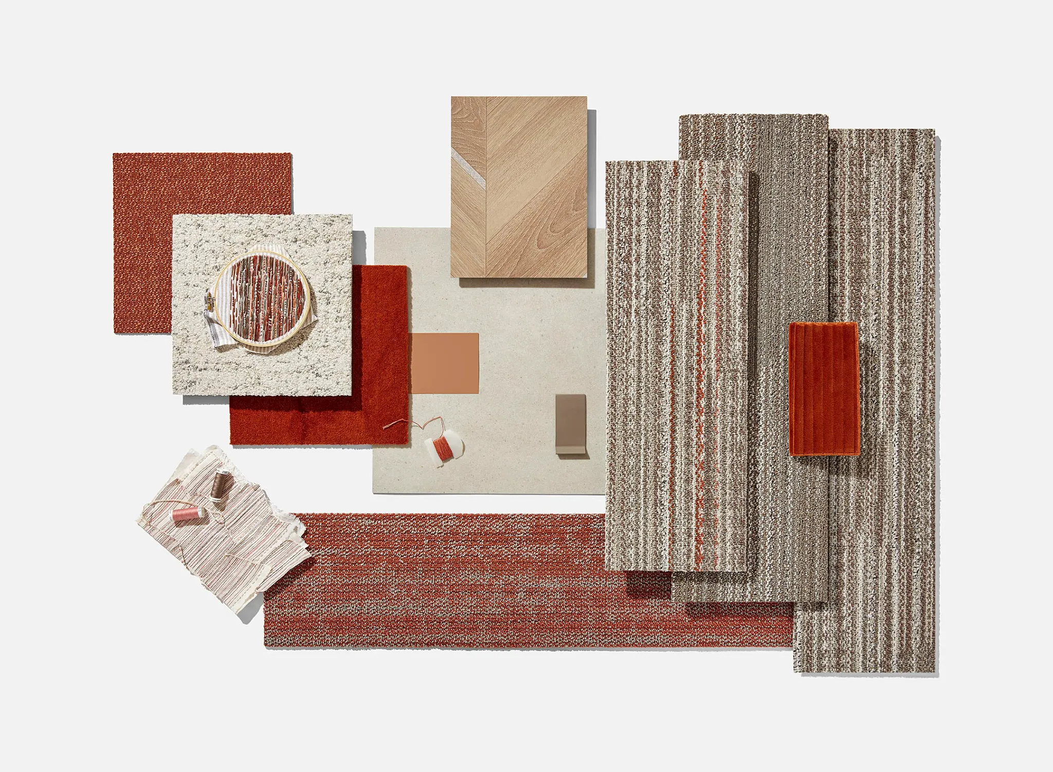 Assorted flooring swatches including commercial carpet tiles and wood patterns in shades of red, beige, and brown