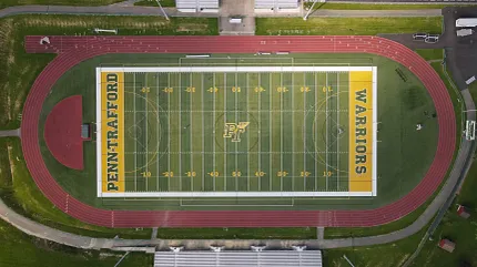 Sports field and track from above Aerial view of a sports field with track and bleachers