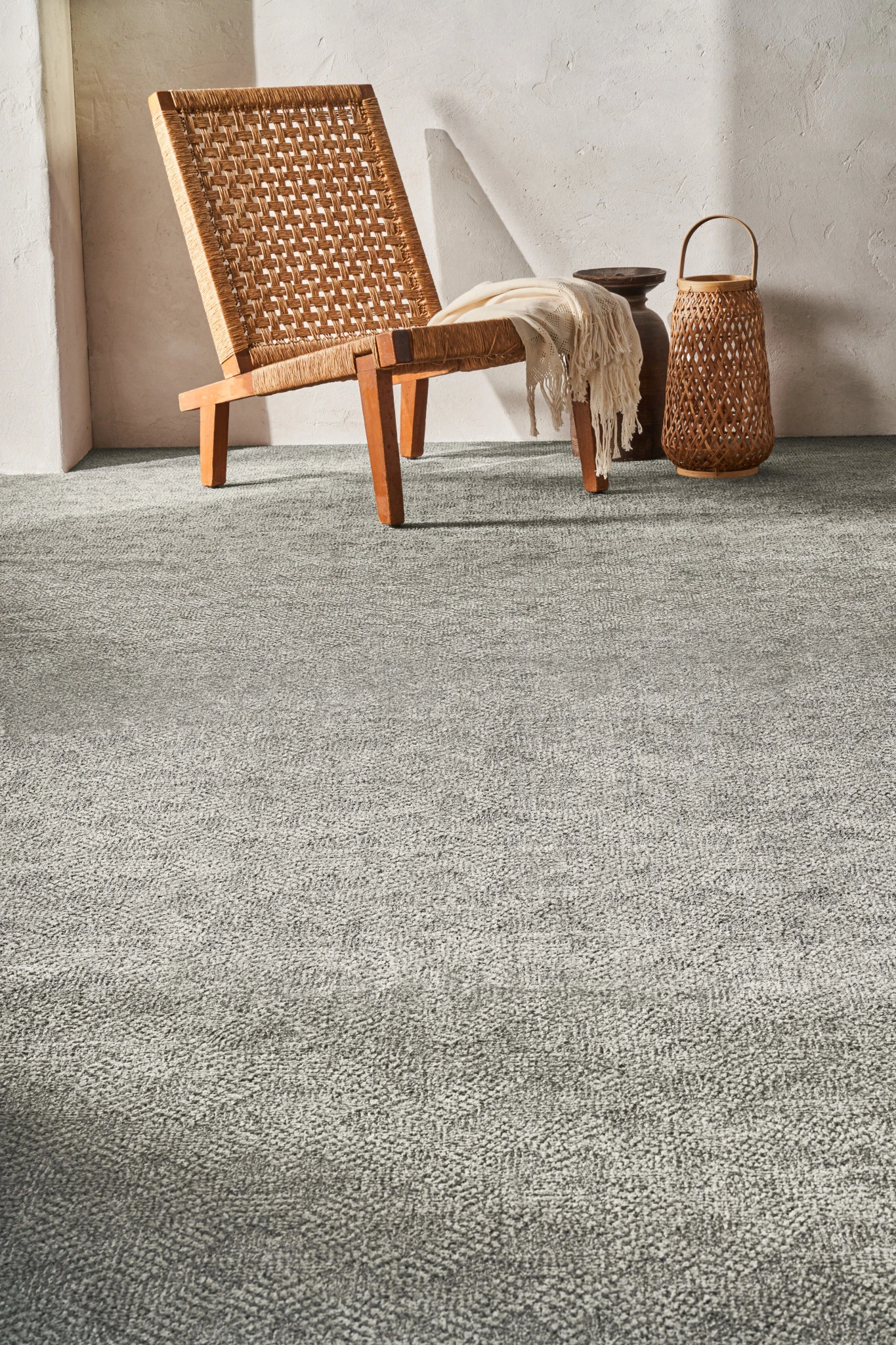 Cozy room scene with a woven chair and basket on a soft grey carpet