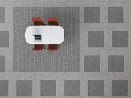 Modern Office Setup with Grey Commercial Carpet Tile Flooring Overhead view of a modern office setup with a white oval table, two red chairs, and a laptop on a grey commercial carpet tile floor