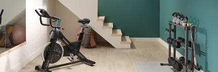 Home Gym with Light Wood Look LVP Flooring - Durable and Stylish Modern home gym with exercise bike and weights on light wood look luxury vinyl plank flooring